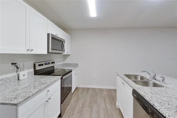 a kitchen with granite countertop a stove and a microwave