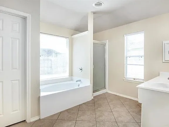 a spacious bathroom with a bathtub and a shower