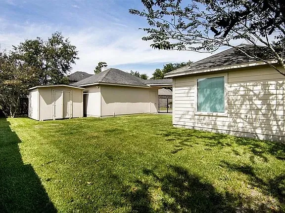 a view of a backyard with plants and large tree