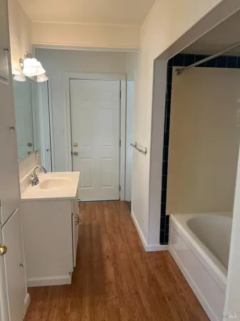 a bathroom with a tub sink and mirror