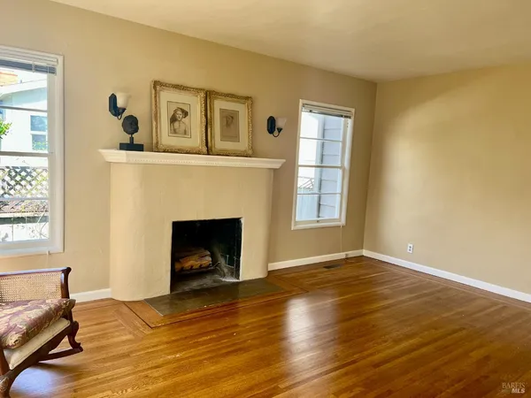 a view of an empty room with window and fire place