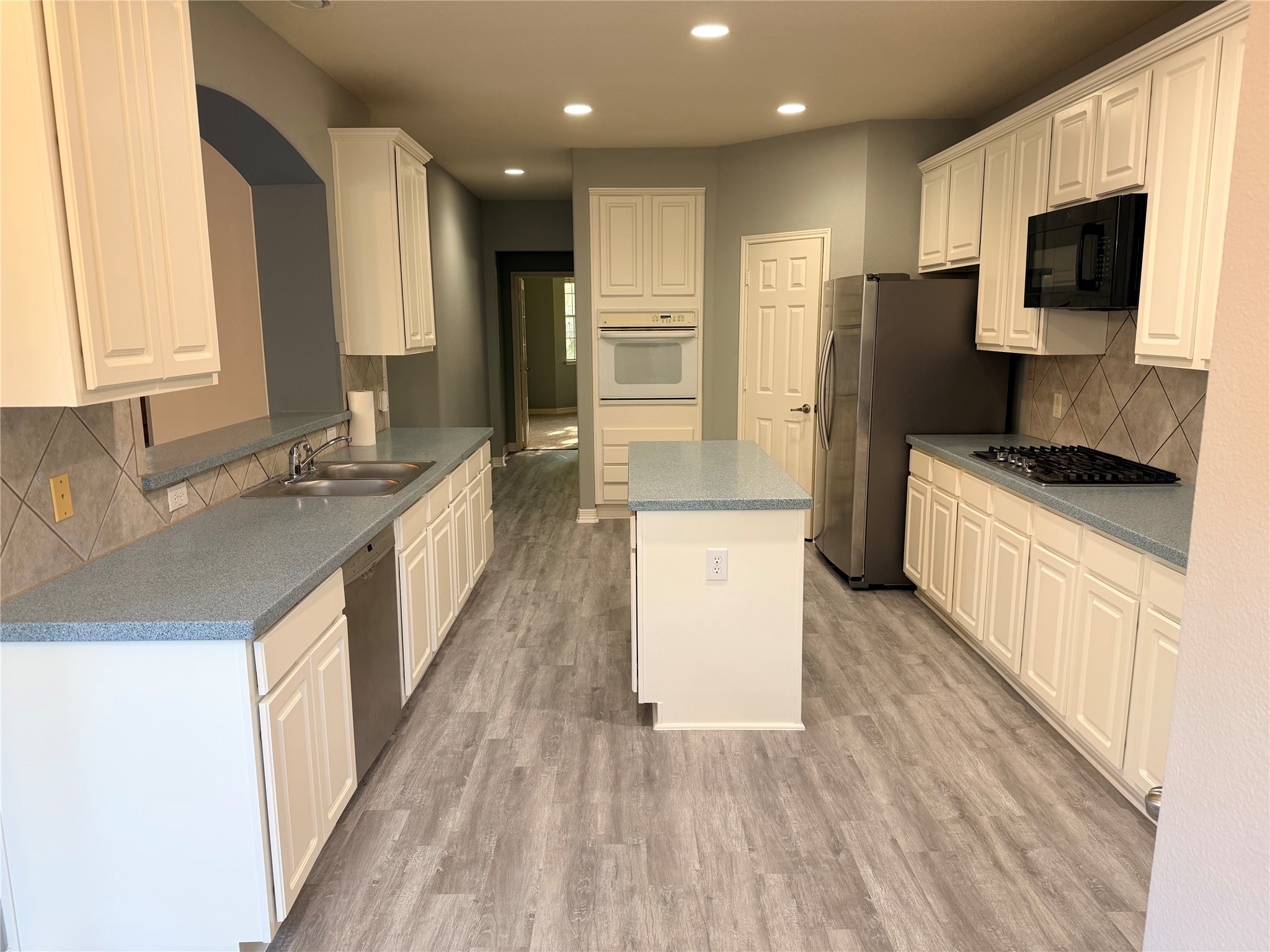 2303 Chelsea Ridge Court Katy, TX 77450 - Photo 5 of 12 a large kitchen with stainless steel appliances kitchen island granite countertop a sink stove and refrigerator