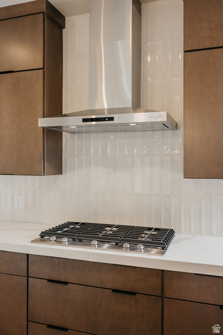 5910 Canyon Rim Road, Unit 619 Lehi, UT 84048 - Photo 7 of 52 Stainless steel range hood, built-in gas cooktop, light-toned countertop, and dark wood-finish cabinetry with linear hardware