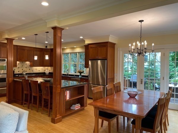 31 Percy Road Lexington, MA 02421 - Photo 2 of 25 a kitchen with stainless steel appliances granite countertop a refrigerator a sink a stove and a dining table with wooden floor
