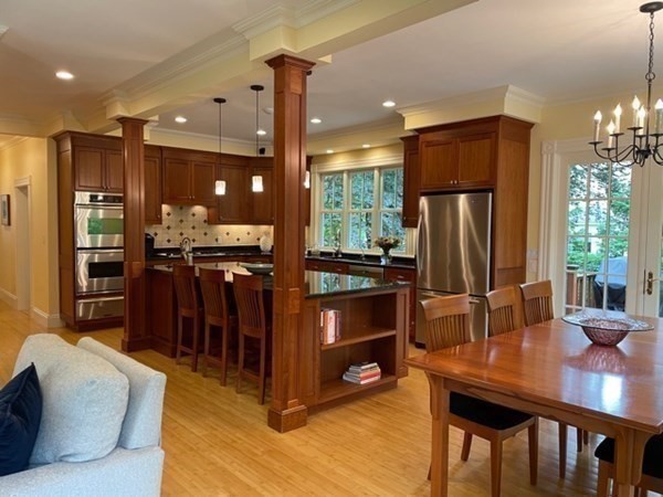 31 Percy Road Lexington, MA 02421 - Photo 10 of 25 a kitchen with stainless steel appliances kitchen island granite countertop a refrigerator a stove a sink a dining table and chairs