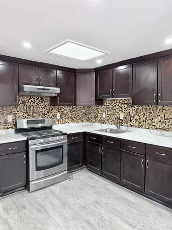 a kitchen with stainless steel appliances granite countertop a sink stove and cabinets