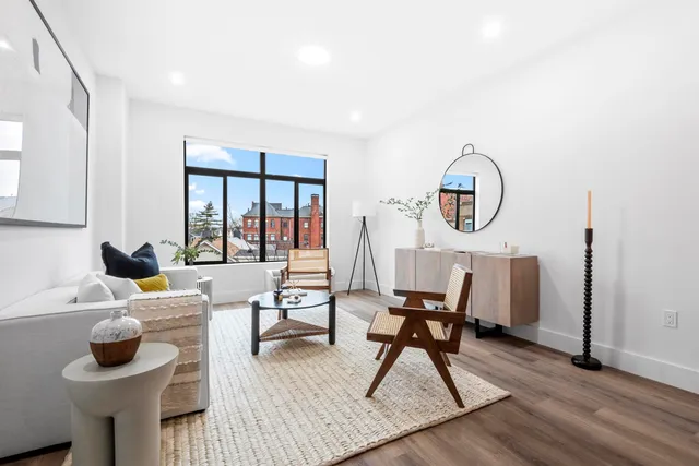 a living room with furniture a window and wooden floor