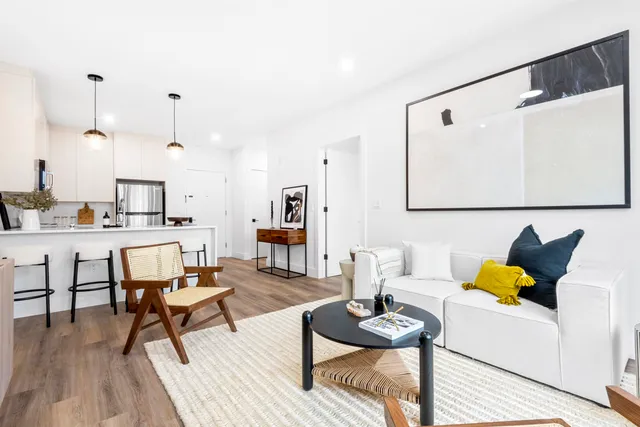 a living room with furniture and kitchen view