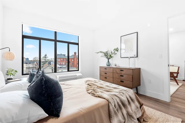 a bedroom with a bed and a large window