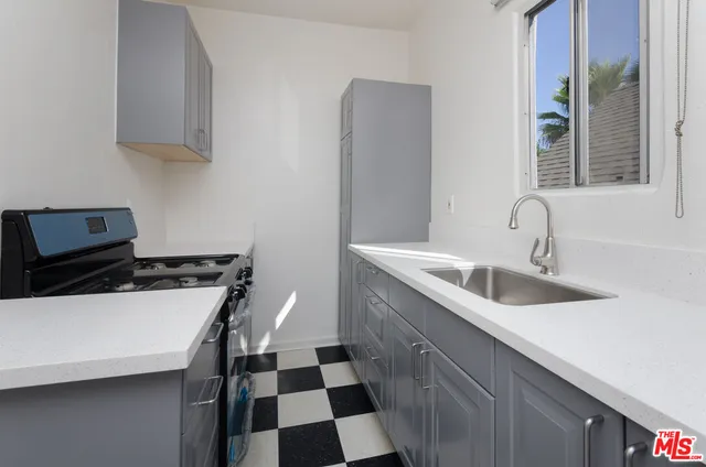 a kitchen with a stove and a flat screen tv