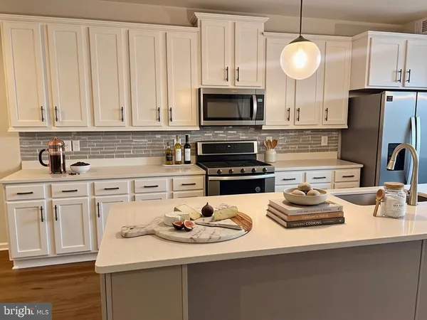 a kitchen with white cabinets and appliances