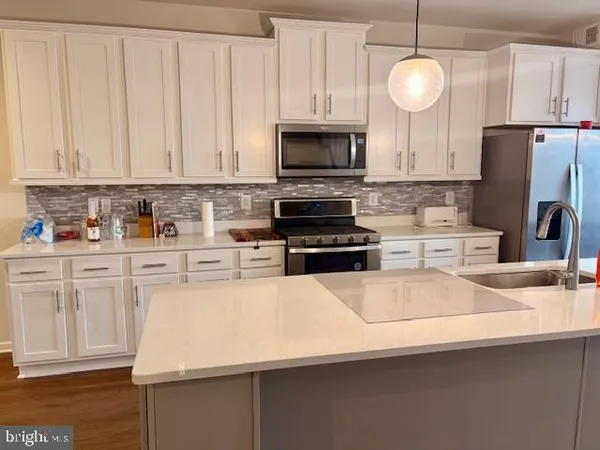 a kitchen with stainless steel appliances a stove a sink and a refrigerator