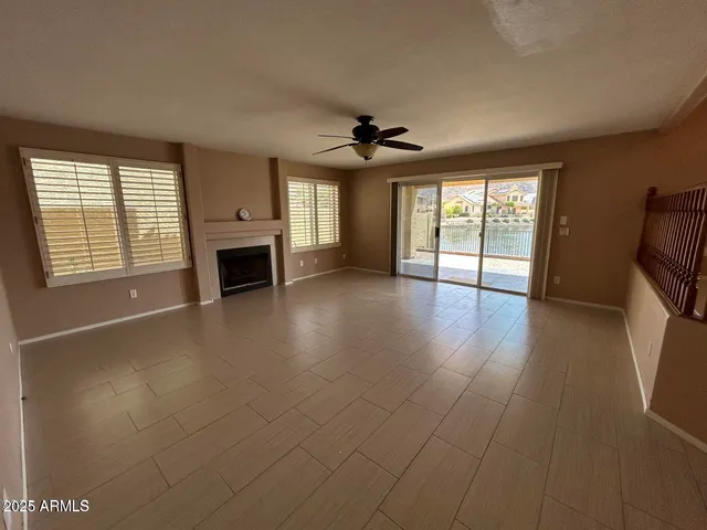 wooden floor fireplace and windows in an empty room