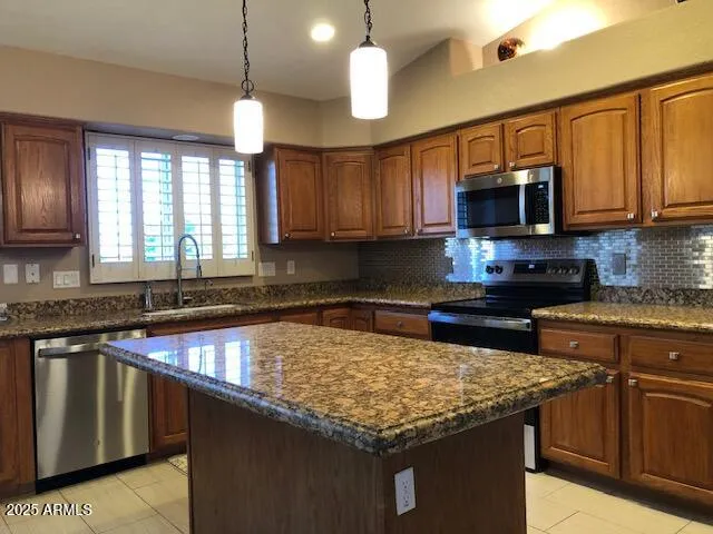 a kitchen with stainless steel appliances granite countertop a sink stove and microwave