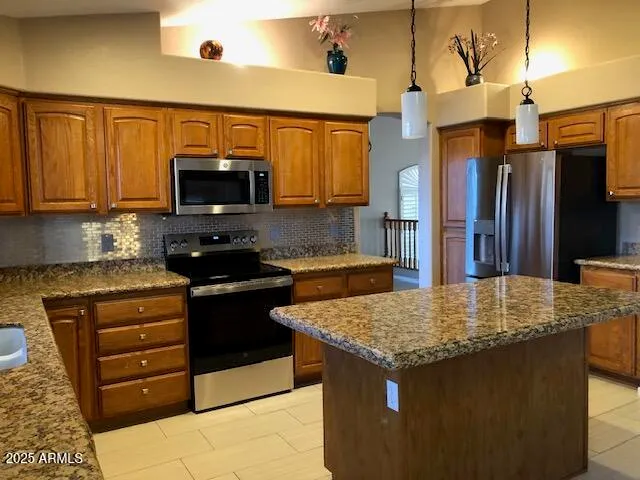 a kitchen with stainless steel appliances granite countertop a stove top oven a sink and a microwave