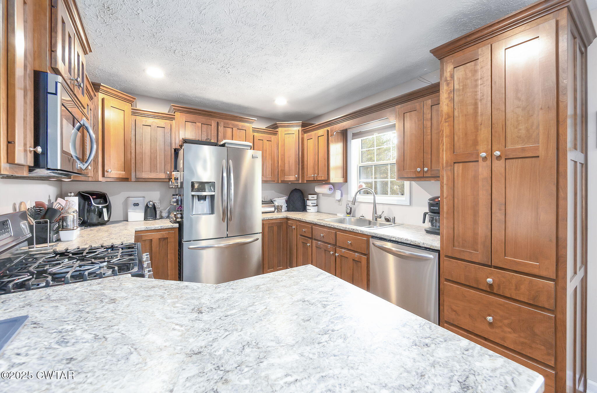 715 Pine Ridge Road Lexington, TN 38351 - Photo 10 of 49 a kitchen with granite countertop stainless steel appliances a refrigerator sink and microwave