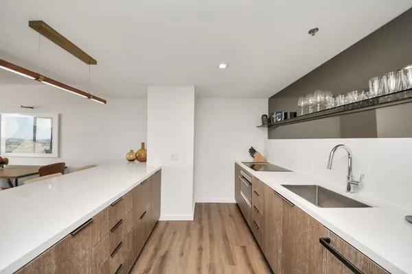 a view of a kitchen with a sink and wooden floor