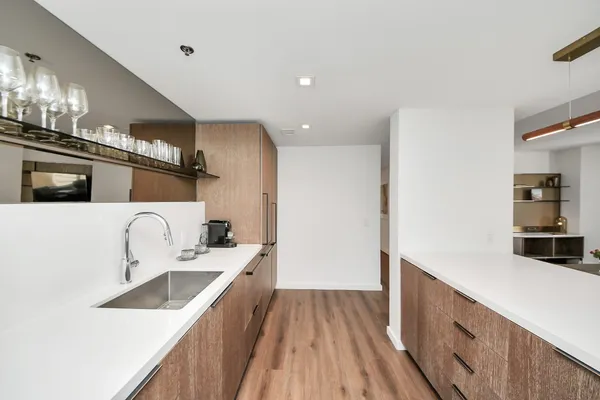 a kitchen with a sink a counter top space stainless steel appliances and cabinets