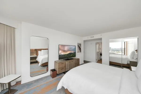 a spacious bedroom with a bed and a flat screen tv