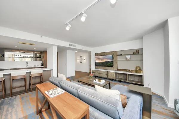 a living room with furniture a rug and kitchen view
