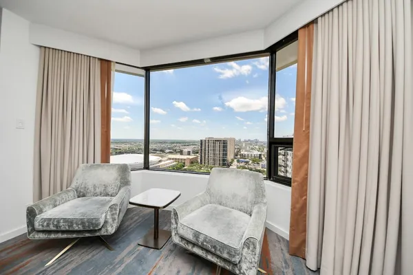a living room with furniture and a large window with outer view