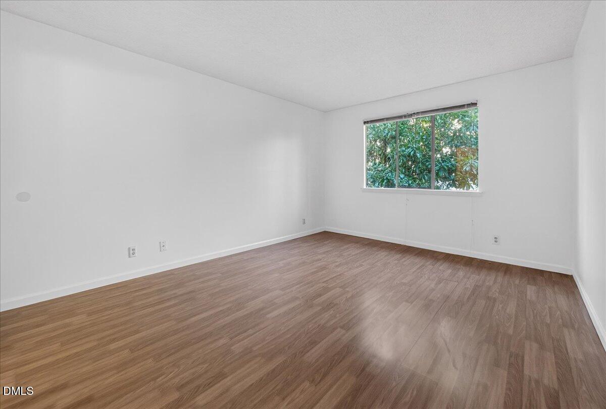 3088 Colony Road, Unit 3088D Durham, NC 27705 - Photo 16 of 25 a view of an empty room with wooden floor and a window