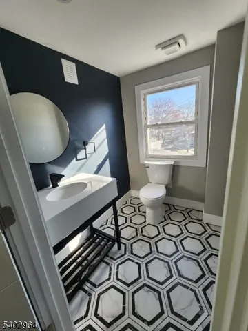 a bathroom with a sink toilet and mirror