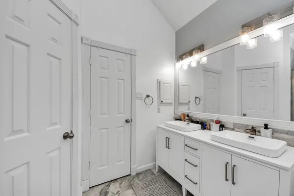 a bathroom with double vanity sink and a mirror