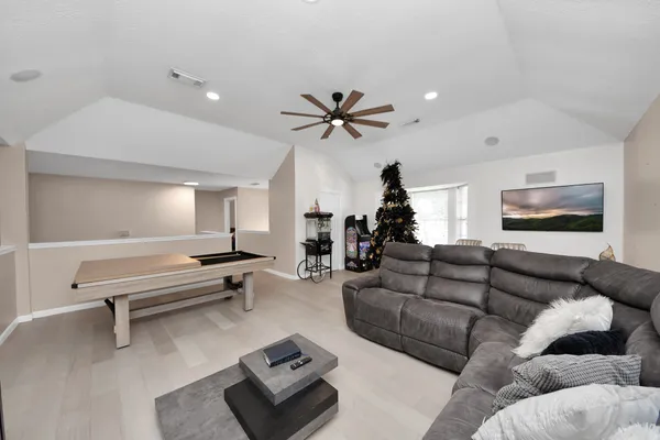 a living room with furniture and a ceiling fan