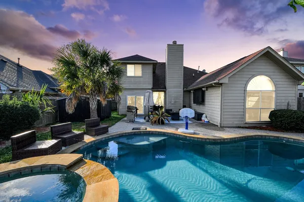a view of a house with swimming pool and sitting area