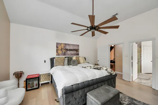 a bedroom with a bed a couch and a chandelier