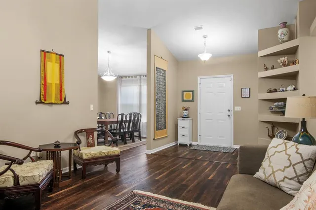 a view of a dining room with furniture wooden floor and a book shelf
