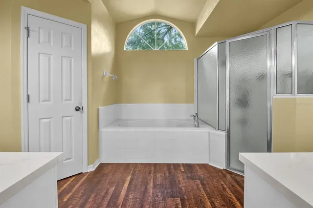 a bathroom with a tub sink and mirror