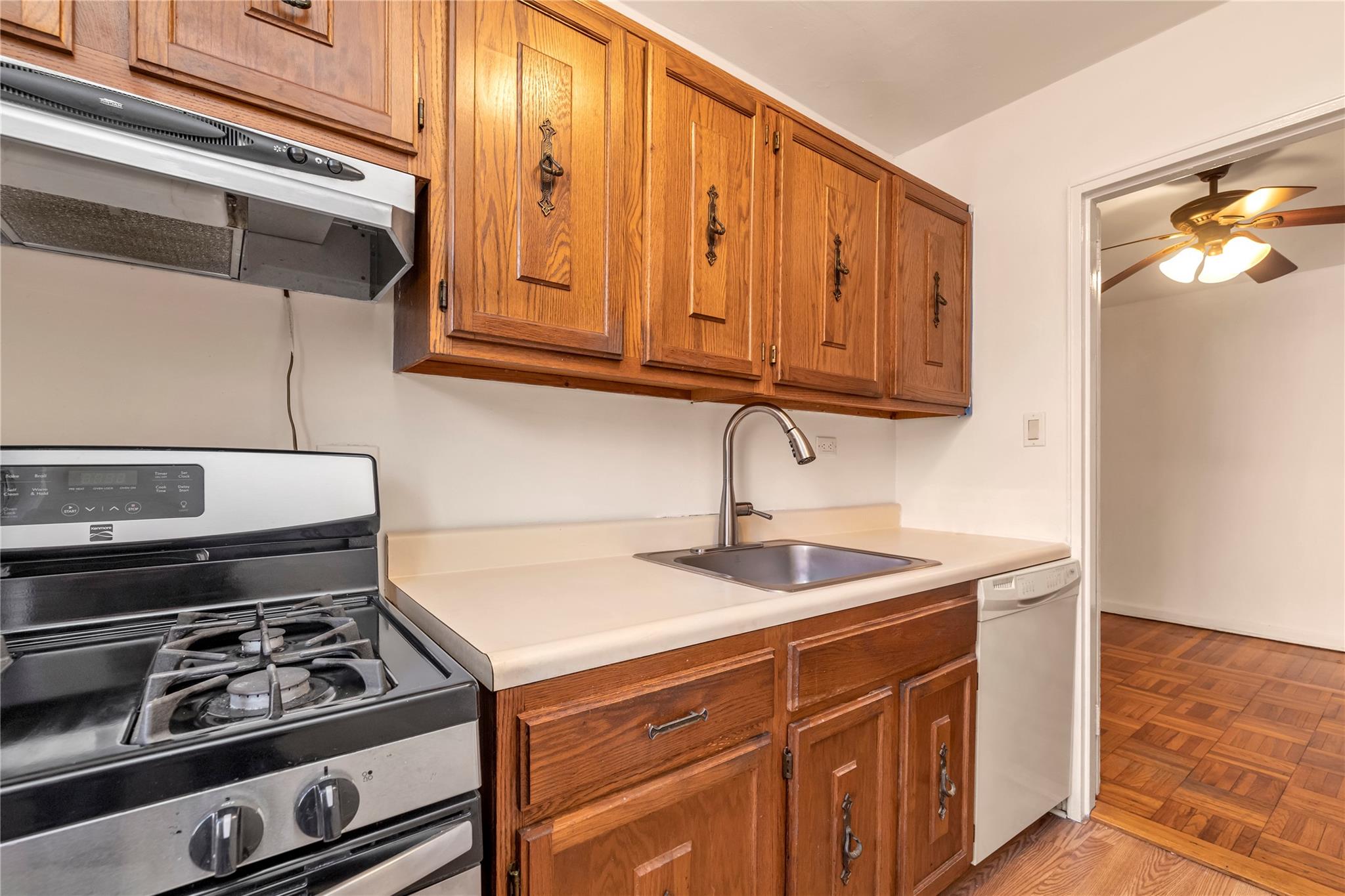 141-05 Pershing Crescent, Unit 210 Queens, NY 11435 - Photo 15 of 22 Kitchen featuring parquet flooring, gas stove, ceiling fan, sink, and dishwasher