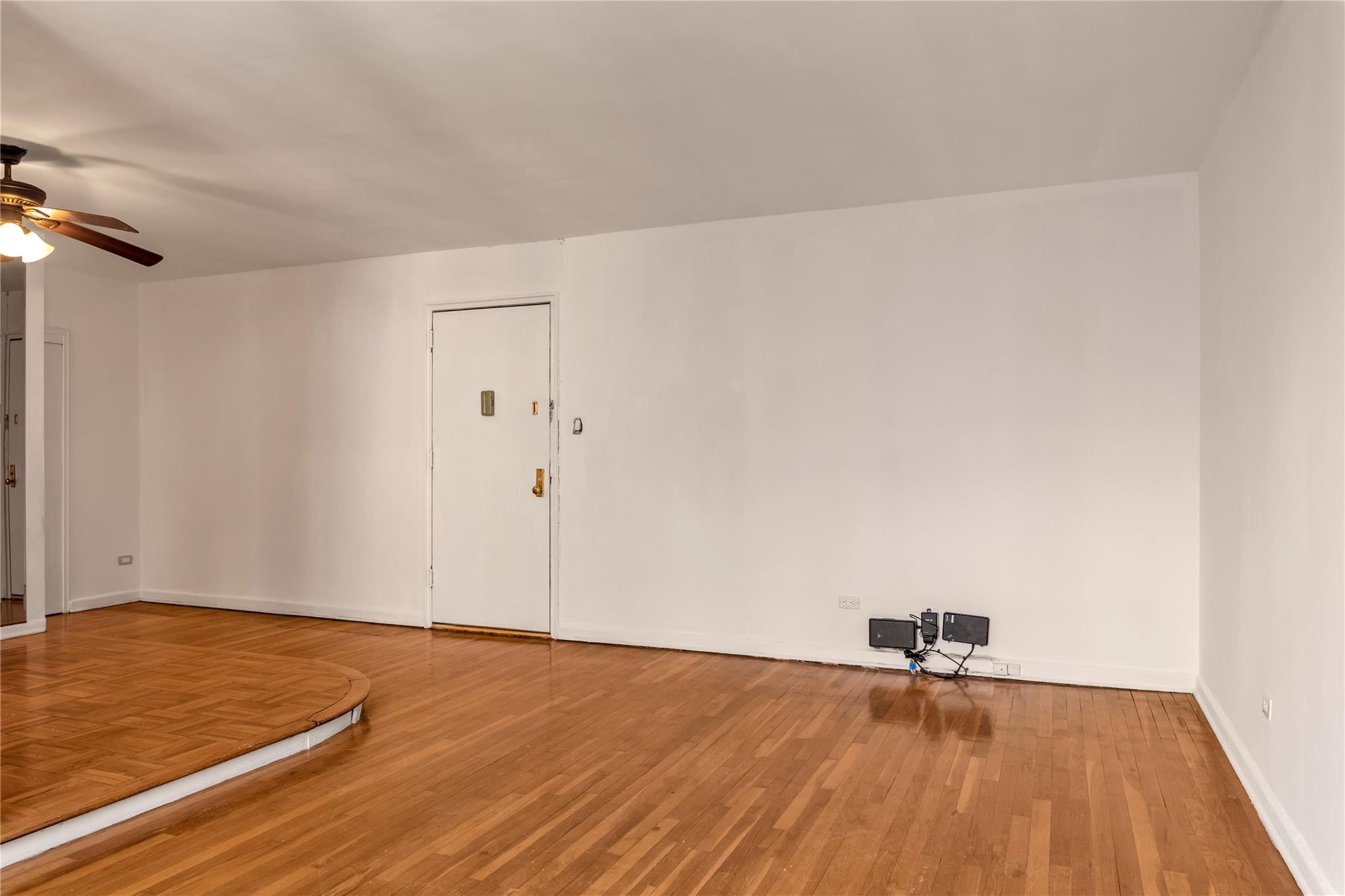 141-05 Pershing Crescent, Unit 210 Queens, NY 11435 - Photo 9 of 22 Spare room featuring wood-type flooring and ceiling fan