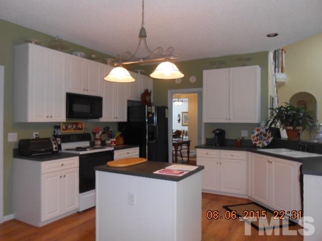 5404 Calverton Drive Raleigh, NC 27613 - Photo 9 of 25 a kitchen with a sink a counter top space appliances and cabinets