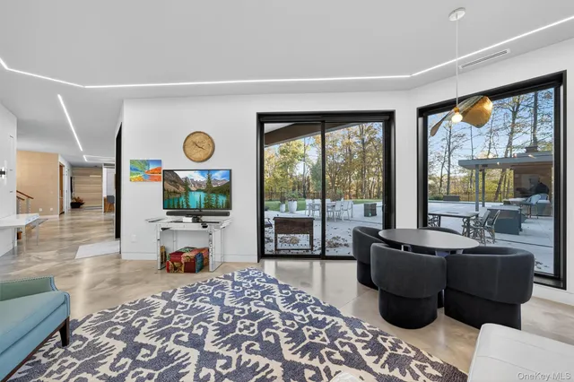 a living room with furniture a chandelier and a flat screen tv