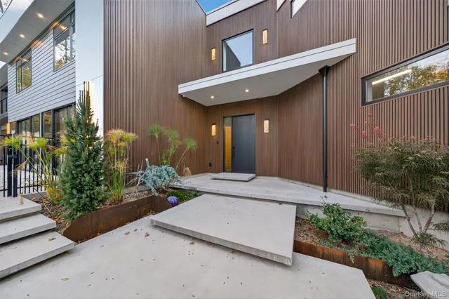 a view of a house with potted plants and a garage