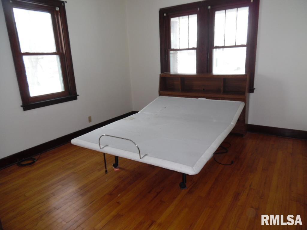 1620 North 3rd Street Clinton, IA 52732 - Photo 7 of 20 an empty room with wooden floor and windows