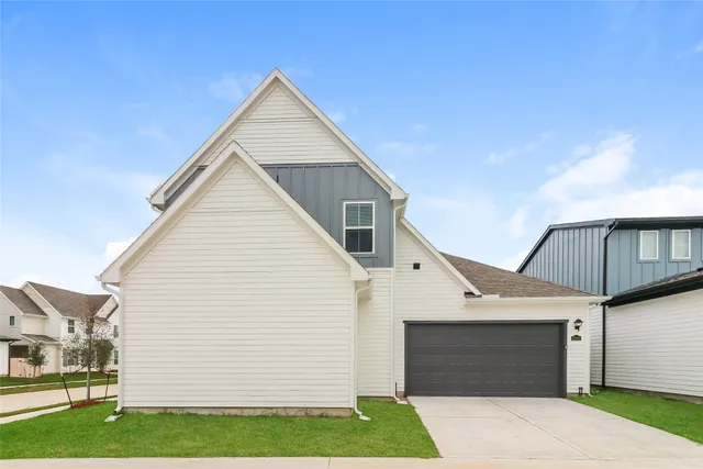a view of a white house with a yard and garage