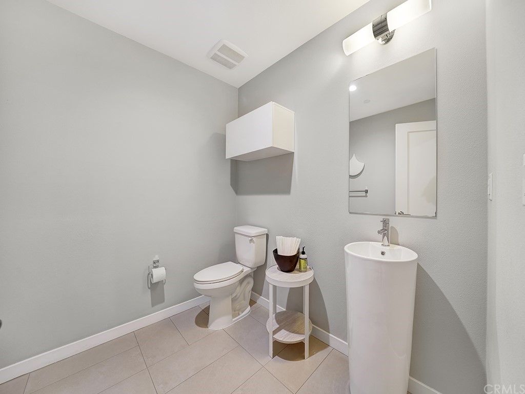 604 Malibu Costa Mesa, CA 92627 - Photo 4 of 40 a bathroom with a toilet sink and mirror