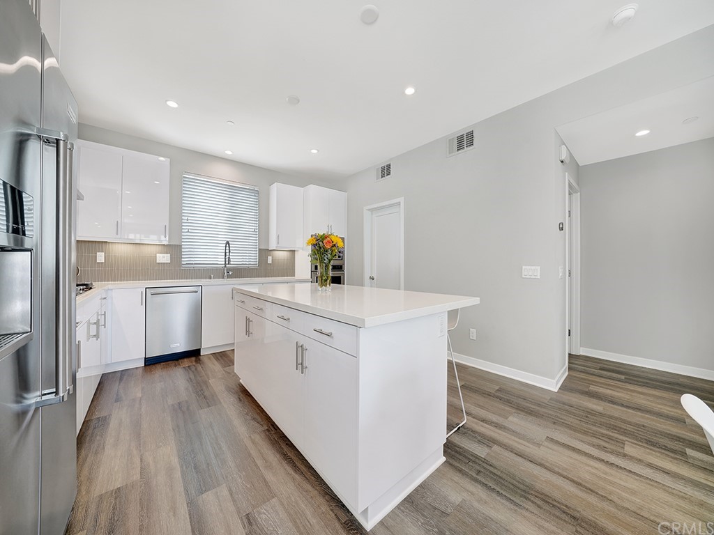 604 Malibu Costa Mesa, CA 92627 - Photo 7 of 40 a kitchen with white cabinets appliances and sink