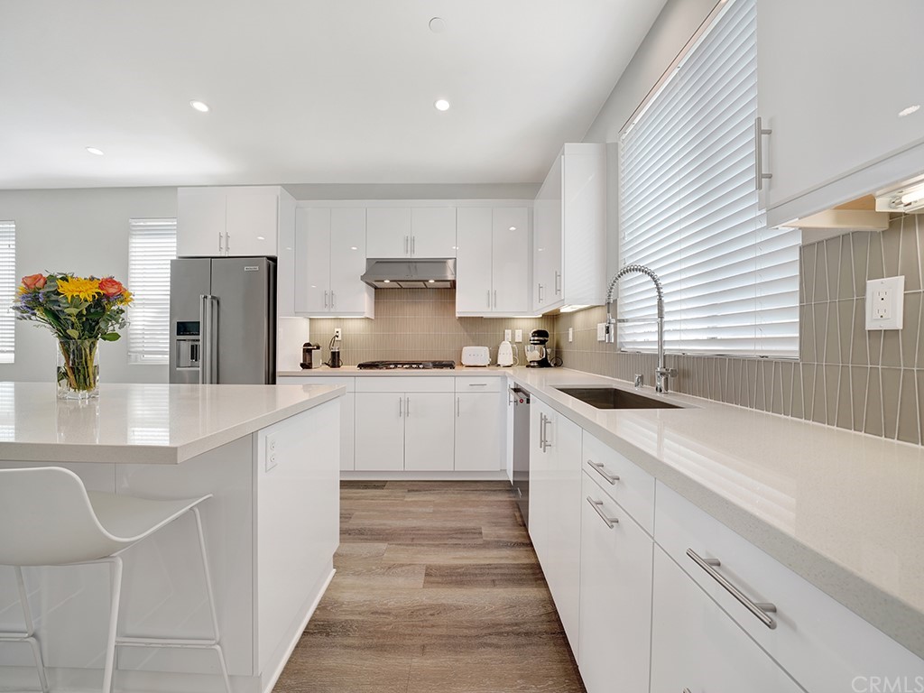 604 Malibu Costa Mesa, CA 92627 - Photo 9 of 40 a large white kitchen with a white stove top oven and white cabinets