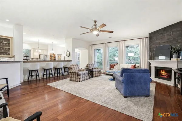 a living room with furniture kitchen view and a chandelier