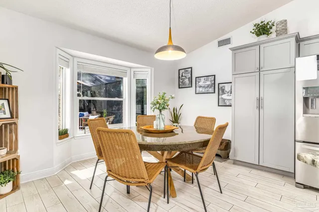 a dining room with furniture a chandelier and wooden floor