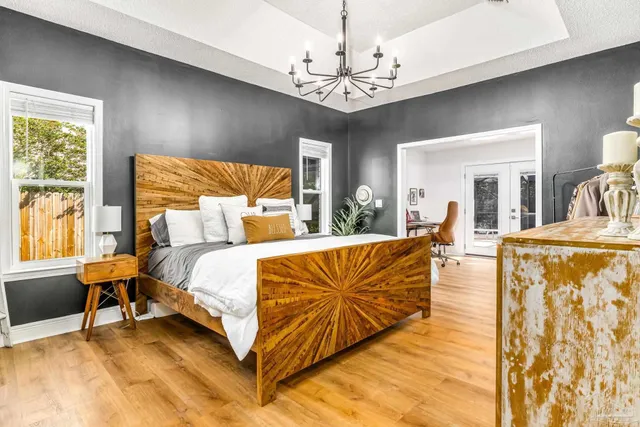 a spacious bedroom with a bed and a chandelier