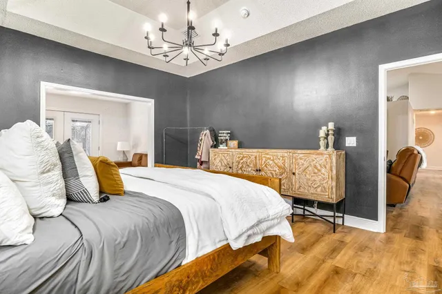 a bedroom with a bed and a chandelier