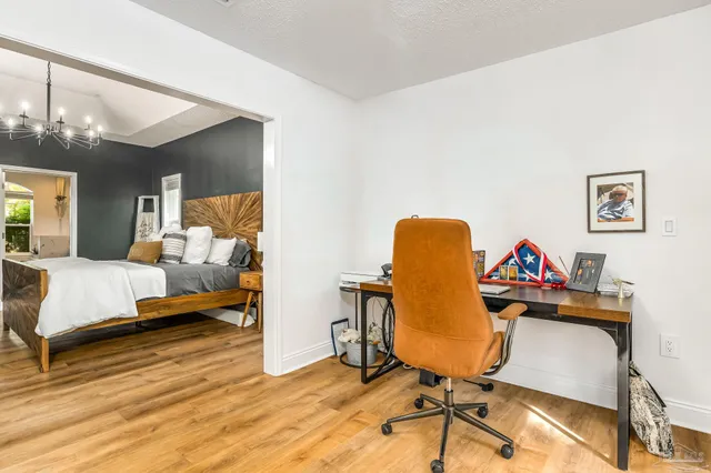 a view of a workspace with furniture and wooden floor