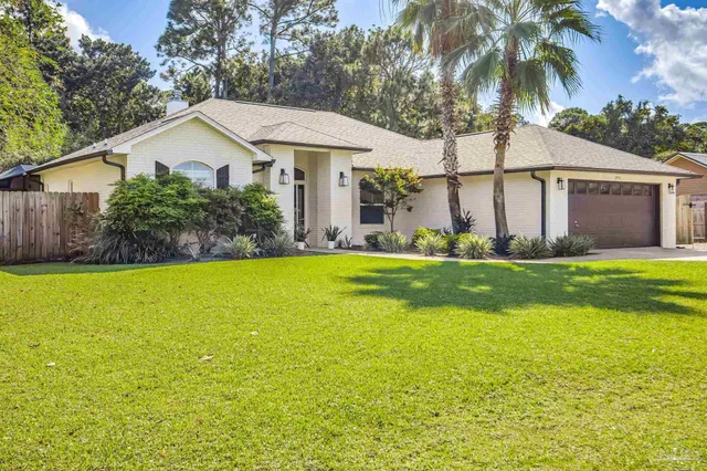 a front view of a house with swimming pool and green space