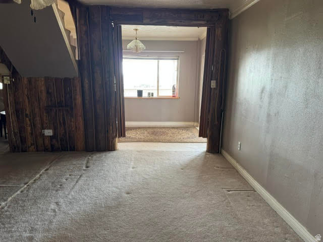 1124 Washam Road Green River, WY 82938 - Photo 20 of 35 Carpeted interior space with a wood-clad staircase and a wide entryway featuring a decorative light fixture